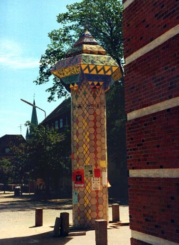 Fotograf: Eget foto
Værk  titel: Plakatsøjle 
Værk  type: Keramisk brugsting/skulptur 
Materiale: Keramik, beton 
Størrelse: Højde 750 cm - diameter 125 cm 
Færdiggjort: 1989 
Placering: Foran biblioteket, Frederikshavn 